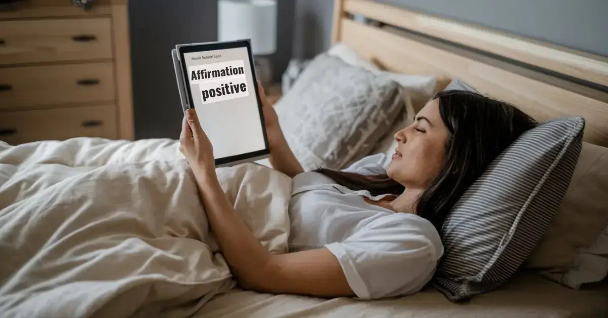 Femme lisant un ebook sur les affirmations positives dans son lit, cultivant la confiance en soi.