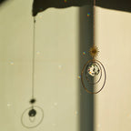 Attrape lumière Galaxy en laiton avec cristal de verre, créant des reflets lumineux sur un mur.