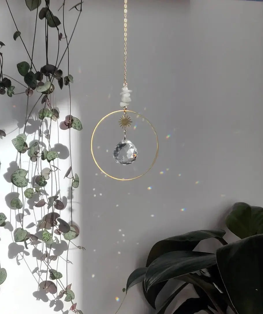 Attrape-soleil Dolce avec pierre de lune, cristal en verre, chaîne dorée, et étoile en laiton créant des jeux de lumière apaisants.