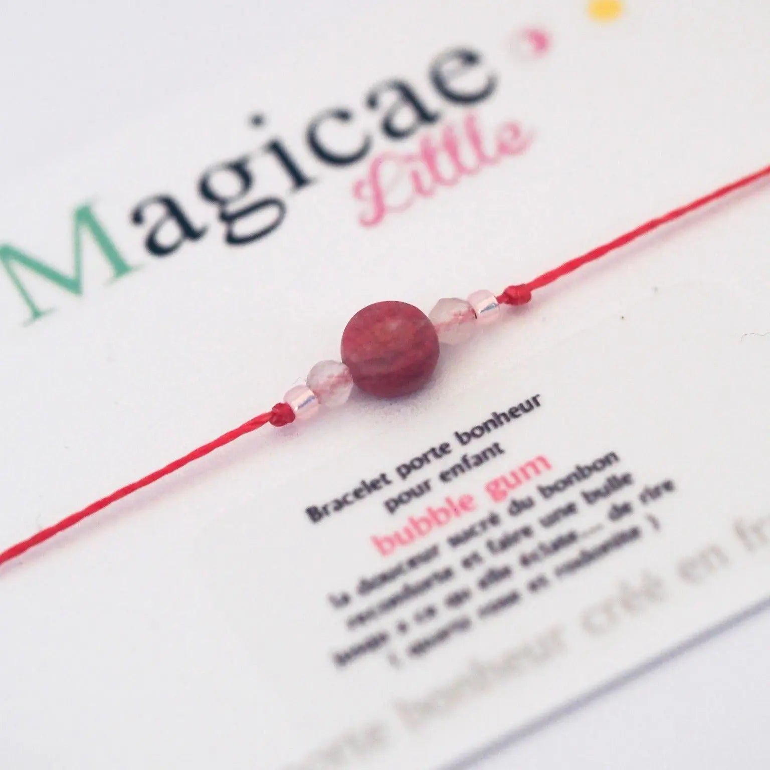 Bracelet porte bonheur enfant Bubble gum en pierres naturelles, avec message positif et attache macramé, sur fond blanc.