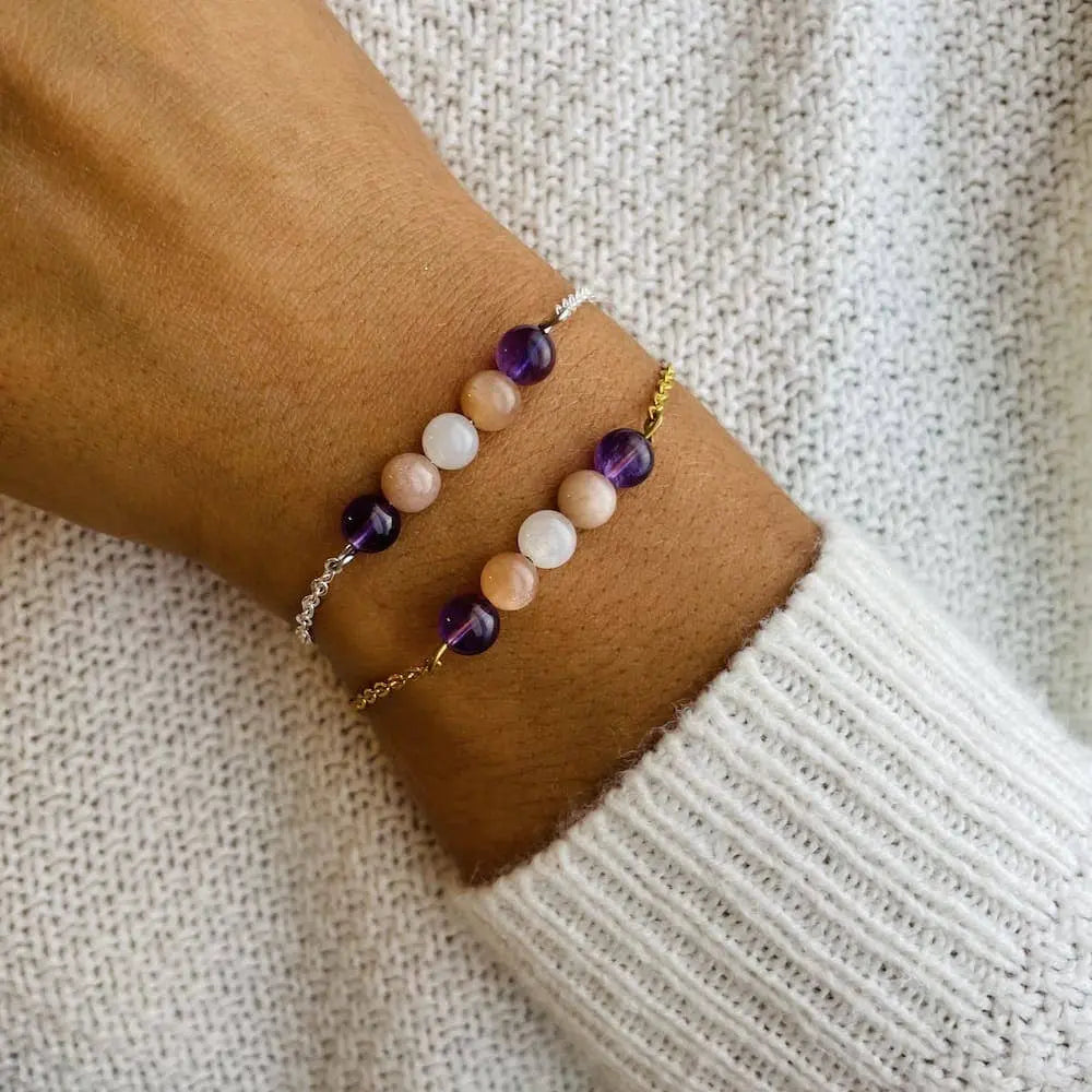 Bracelet Positivité avec améthyste, pierre de lune et pierre du soleil sur un poignet, symbolisant l'énergie positive.
