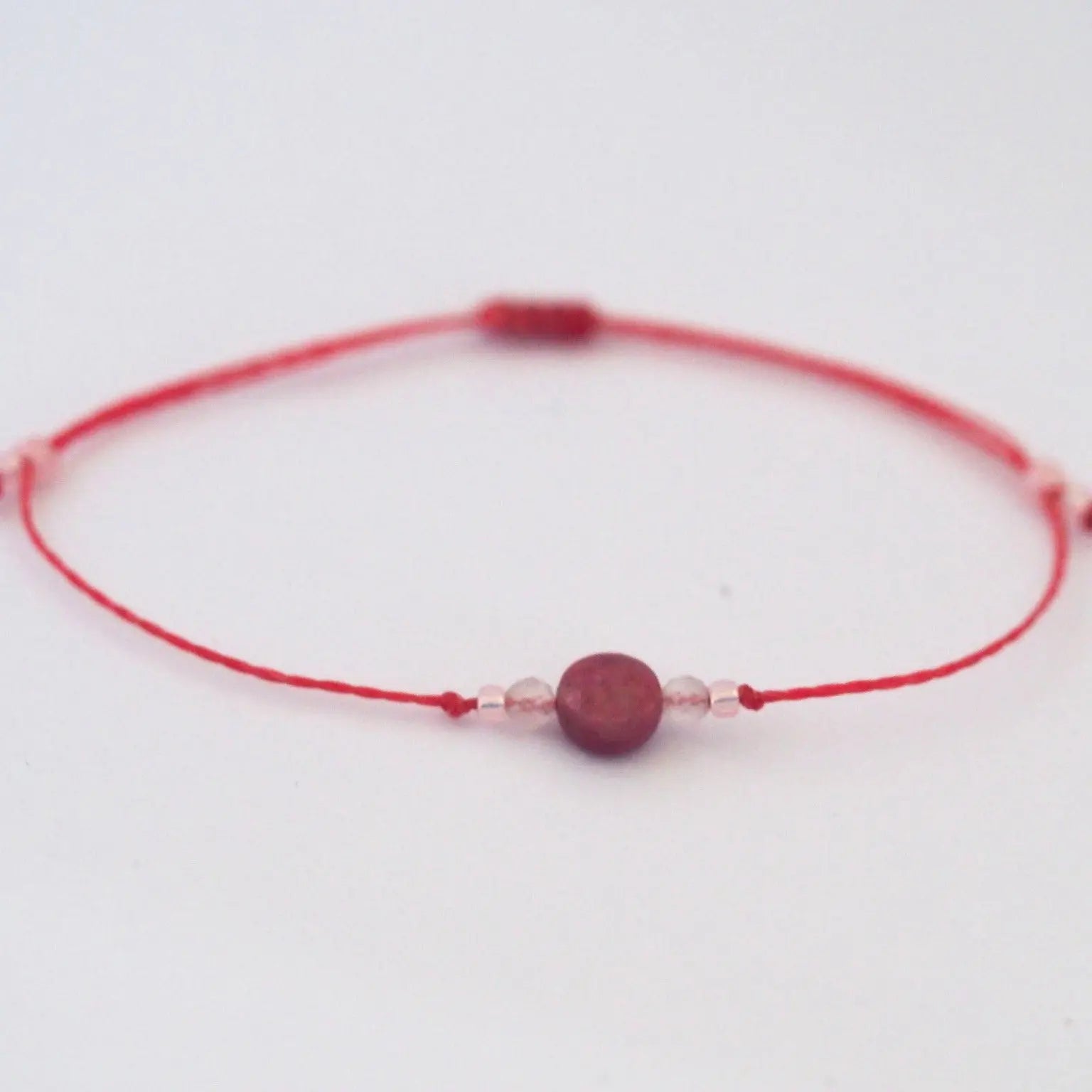 Bracelet porte-bonheur fille Bubble gum en pierres naturelles, attache macramé, sur fond blanc.