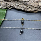 Collier en hématite pour femme, avec chaînes dorée et argentée, sur fond de pierre naturelle.