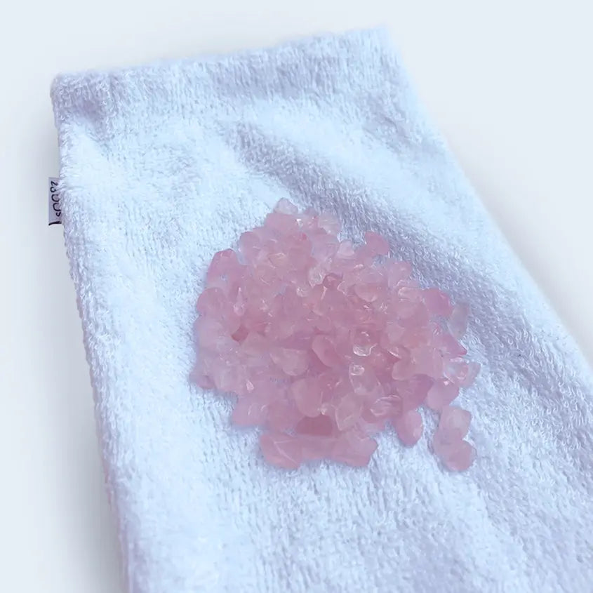 Masque quartz rose Tas de cristaux de quartz rose sur une serviette blanche, idéal pour un masque relaxation yeux.