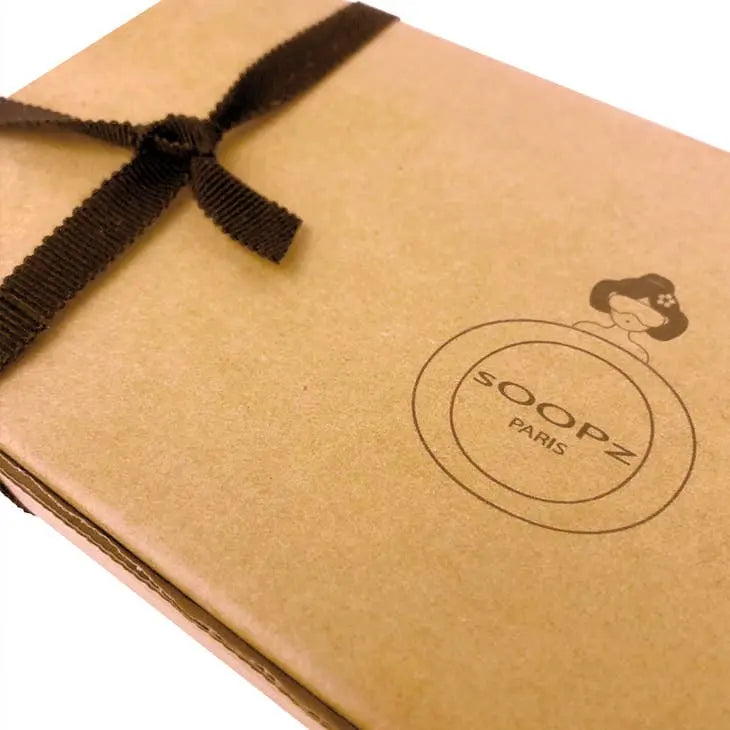 Packaging de Soopz Paris avec un ruban marron et un logo design sur des matériaux écologiques. Masque quartz rose