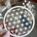 Fleur de vie en bois avec pierres, utilisée pour recharger vos pierres et purifier les objets spirituels, sur une surface en bois.