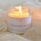 Bougie avec pierre de lithothérapie Féminin Sacré dans un élégant bocal en verre, allumée sur un tissu doux.