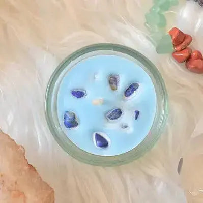 Bougie chakra avec pierres naturelles sur fond doux, idéale pour la lithothérapie et l'énergie.