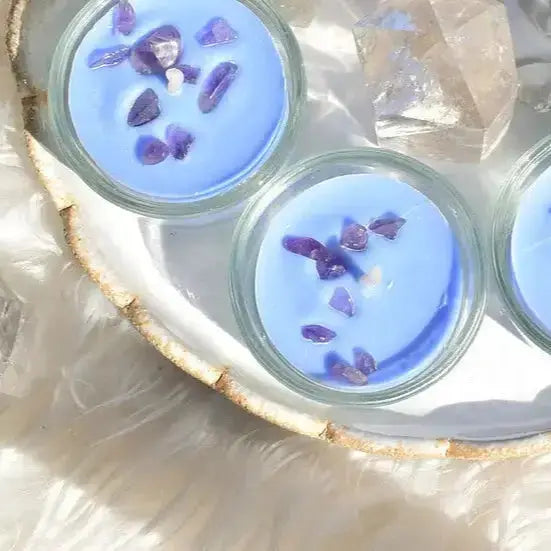 Bougie chakra bleu troisieme œil avec améthyste sur une surface douce, symbole de lithothérapie et d'harmonie.