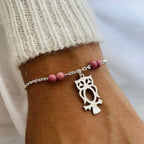 Elégant bracelet charm hibou en argent avec pierres quartz au poignet, symbolisant la sagesse et l'intuition, parfait pour la lithothérapie.