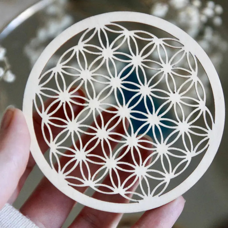 Petite fleur de vie pour recharger les pierres et purifier les objets spirituels, sur une surface en bois.